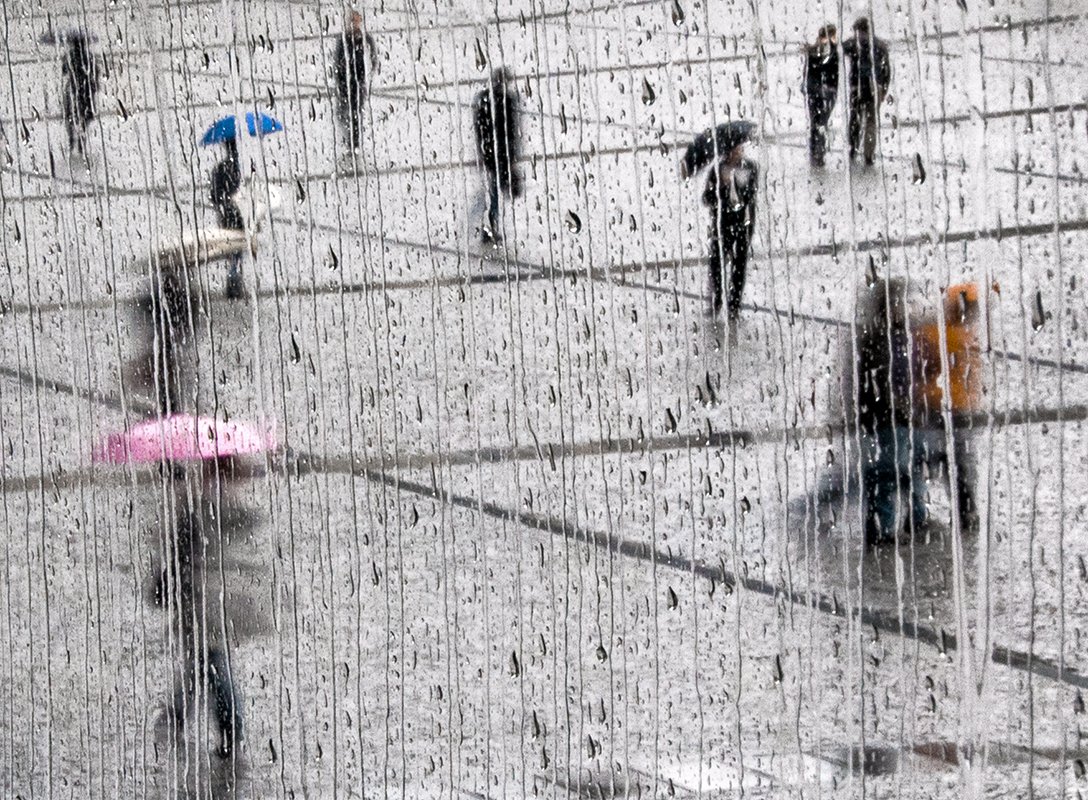 On the criss-crossed esplanade of Beaubourg, urbans in the rain, with pink and blue umbrellas.